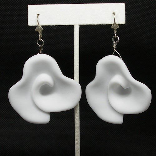 White floral earrings on a black background