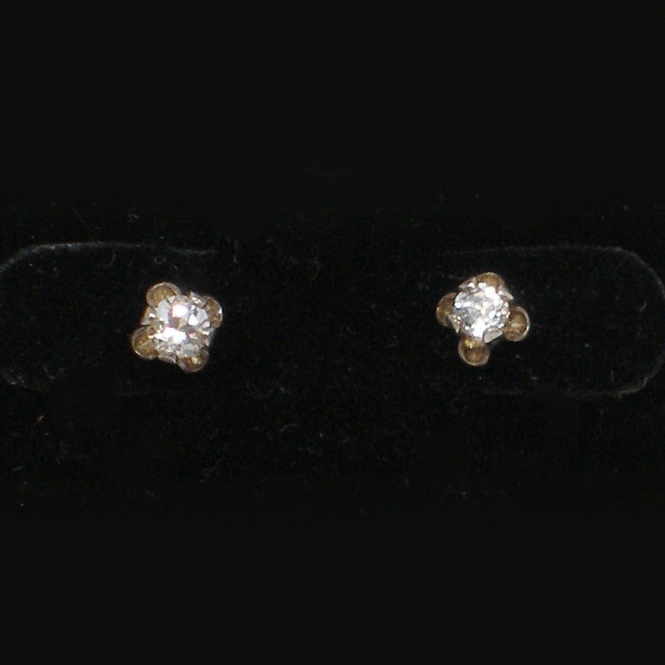 Pair of white zircon stud earrings on a black background
