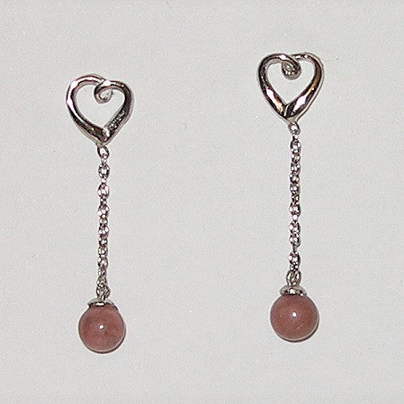 Heart-shaped earrings with pink beads on a white background