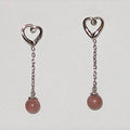 Heart-shaped earrings with pink beads on a white background