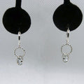 Silver earrings with circular designs and pale blue stones on a gray background