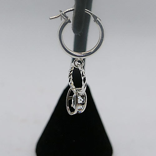 Silver hoop earring with a dangling gemstone charm on a gray background