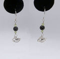 Pair of earrings with black and green beads and silver Swan charms on a white background.