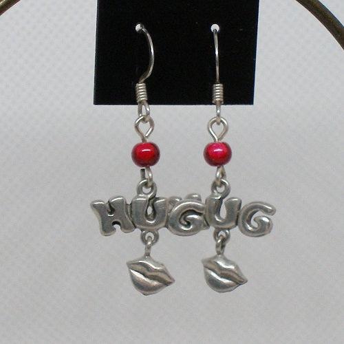 Silver earrings with 'HUGS' and red beads on a white background