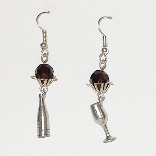 Pair of earrings with wine bottle and glass charms on a white background