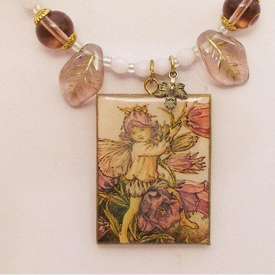 Necklace with fairy pendant and beaded chain on a light background