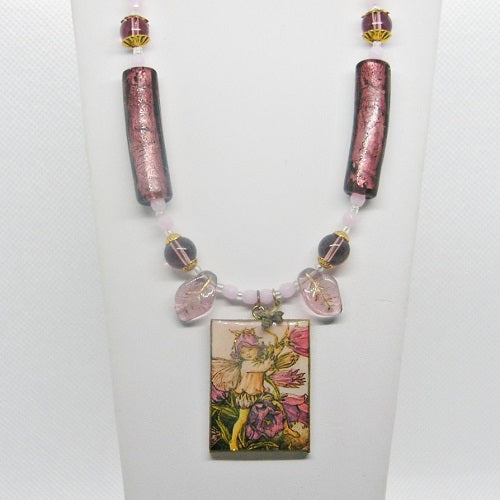 Necklace with fairy pendant and decorative beads on a white background