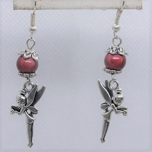 Earrings with fairy charms and pink beads on a white background