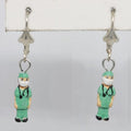 Earrings with doctor figurines wearing green scrubs on a white background