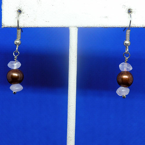 Pair of earrings with brown and pink beads on a blue and white background