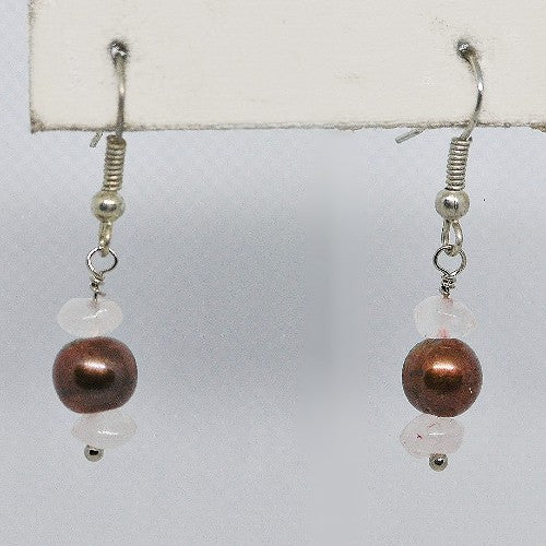 Pair of earrings with brown beads and pale pink stones on a white background