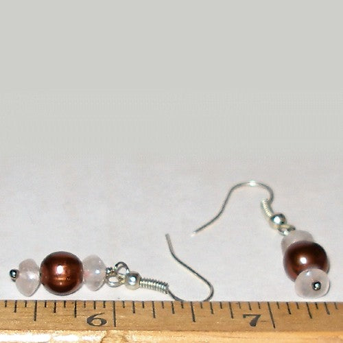 Pair of earrings with brown and pink beads on a white background with a ruler for scale.