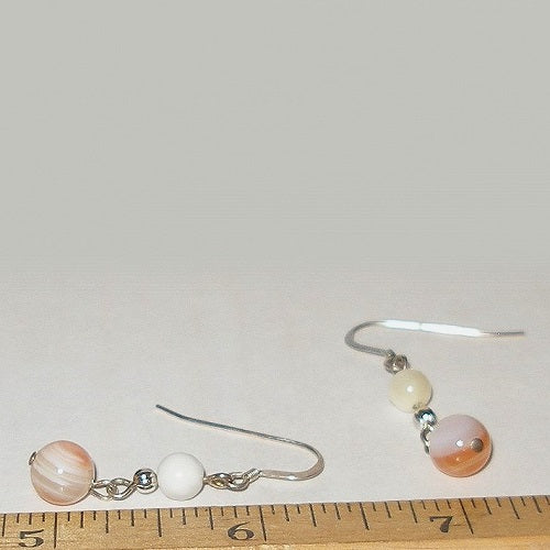 Pair of earrings with beads on a ruler for size reference