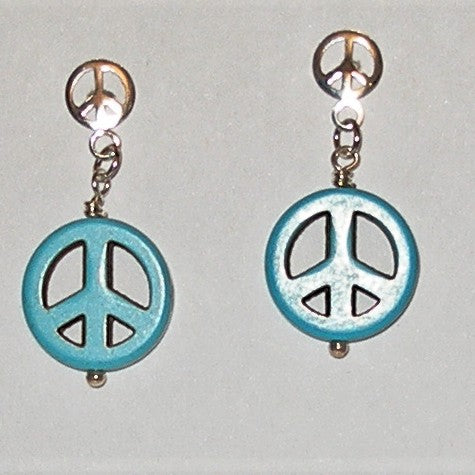 Peace sign earrings with turquoise and silver design on a gray background