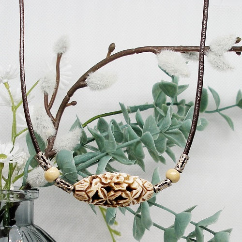 Necklace with decorative bead against a natural background