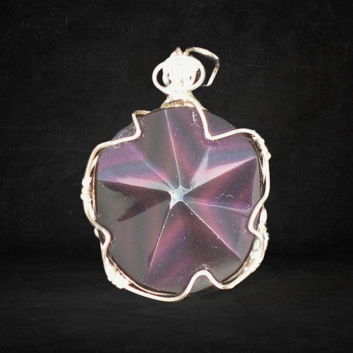 Star-shaped purple stone pendant with silver wire wrapping on a black background