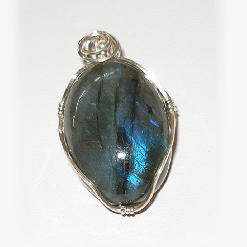 Labradorite pendant with silver wire wrapping on a white background