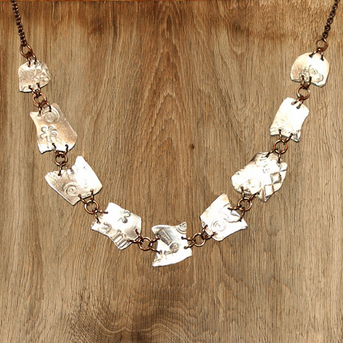 Necklace with unique links on a wooden surface