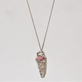 Silver pendant with a pink gemstone on a light gray background