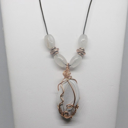 Necklace with a wire-wrapped pendant and beads on a white background