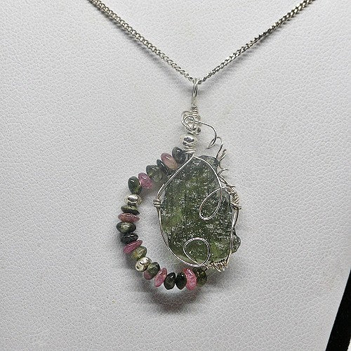 Necklace with a pendant featuring green and pink gemstones on a light gray background
