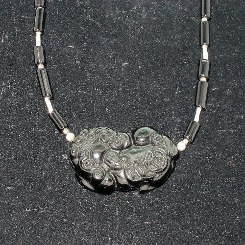 Necklace with a rainbow obsidian pendant on a dark background