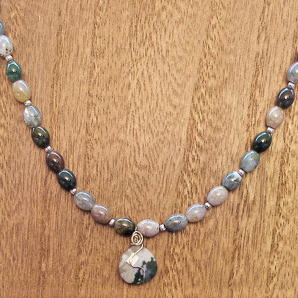 Necklace with multicolored beads and a pendant on a wooden surface