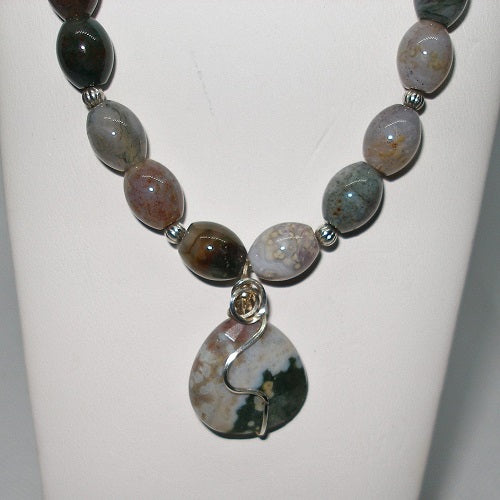 Necklace with natural stone beads and a large pendant on a white background