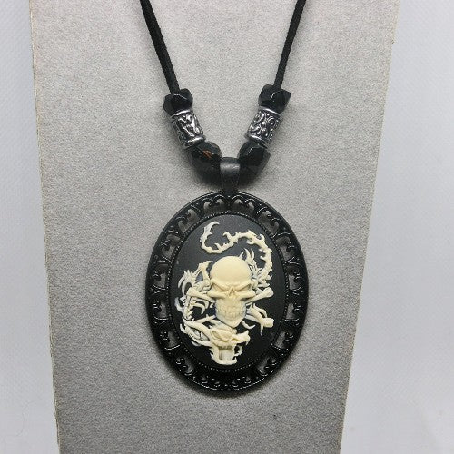 Black pendant with skull design on a gray card