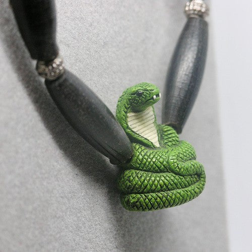 Necklace with a green snake pendant on a gray background