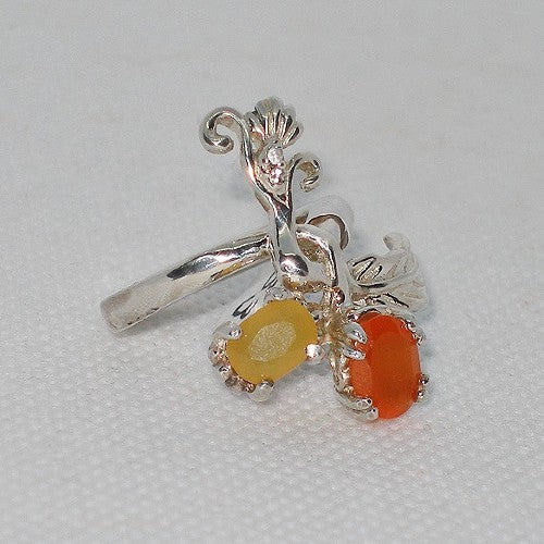 Silver pendant with yellow and orange gemstones on a light gray background