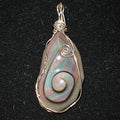 Teardrop-shaped pendant with iridescent stone and silver wire wrapping on a black background