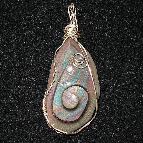 Teardrop-shaped pendant with iridescent stone and silver wire wrapping on a black background