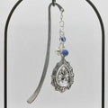 Silver bookmark with decorative pendant and beads on a gray background