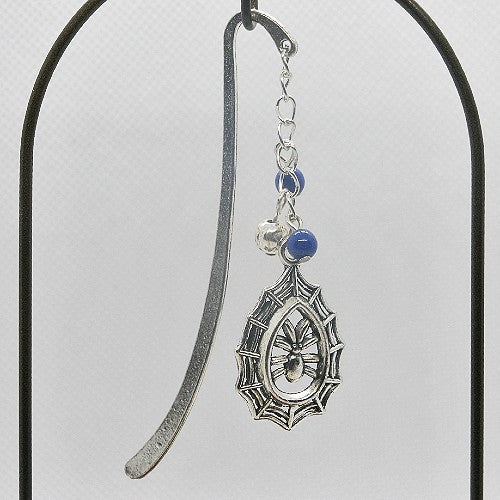 Silver bookmark with decorative pendant and beads on a gray background