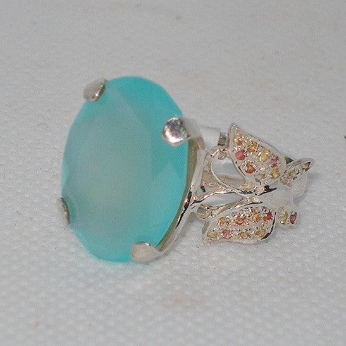 Jewelry with a blue gemstone and butterfly on a light gray background
