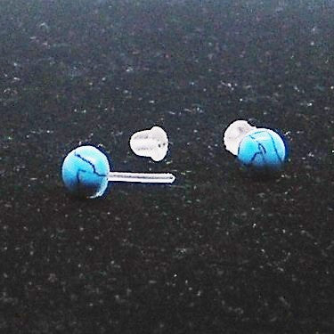 Pair of blue marbled earrings on a black background