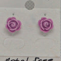 Purple rose-shaped earrings on a white card with text.
