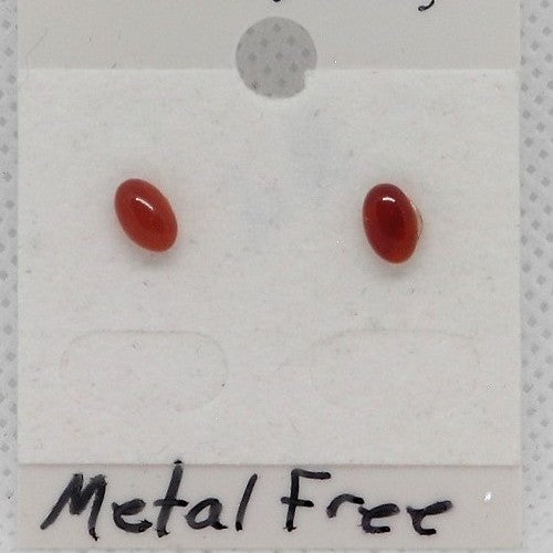 Pair of red oval earrings on a white card with 'Metal Free' text.