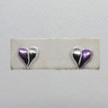 Heart-shaped earrings on a white card with a gray background
