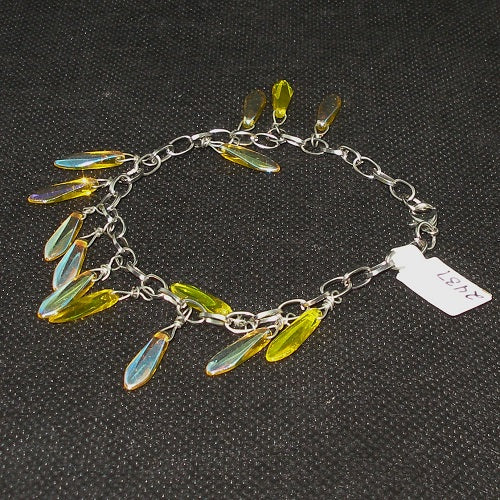 Bracelet with yellow iridescent teardrop-shaped charms on a dark textured background