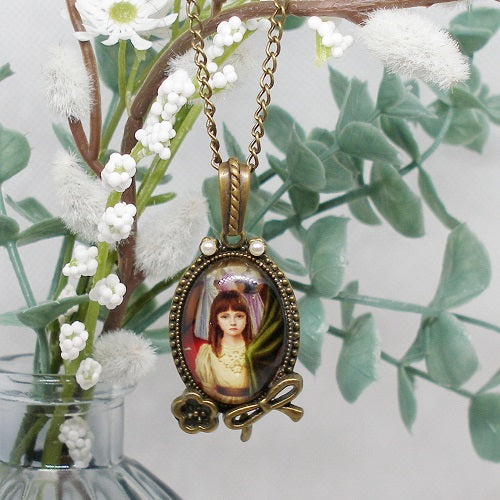 Necklace with a pendant featuring a portrait against a floral background