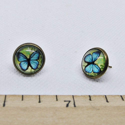 Butterfly-themed earrings on a white background with a ruler for scale.