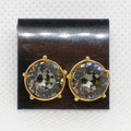 Pair of gold-framed crystal earrings on a black display card.