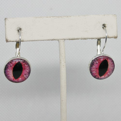Earrings with purple and pink eye-like design on a white stand against a gray background