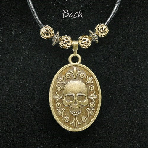 Gold skull pendant necklace on a black background
