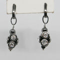 Pair of black metal earrings with clear gemstones on a white background