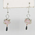 Pair of earrings with pink glass beads and silver hooks on a white background