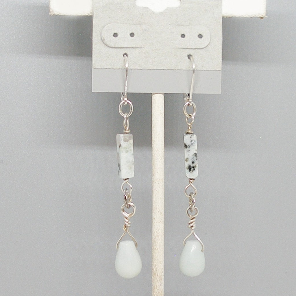 Pair of earrings with stone beads on a gray background