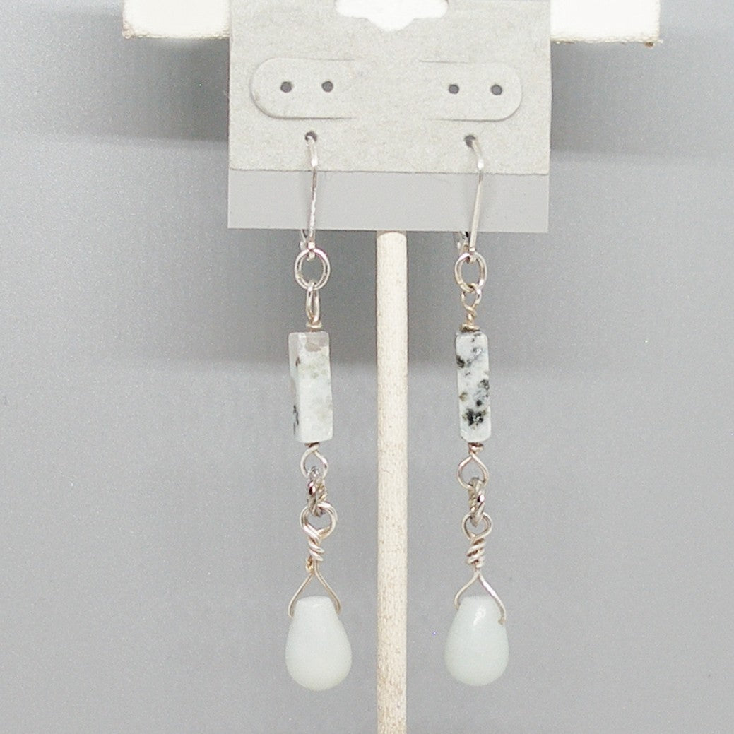 Pair of earrings with stone beads on a gray background